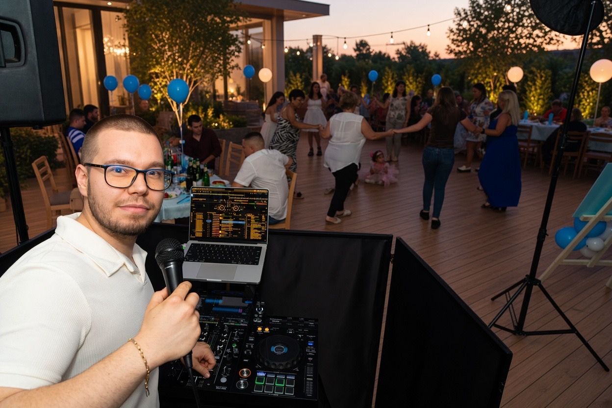 DJ DINKO с микрофон зад DJ пулта на парти на открито
